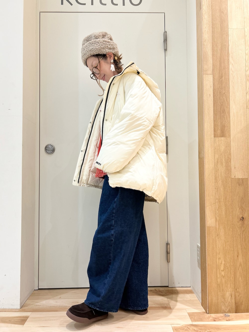 ホワイト系のジャケット/アウター、ホワイト系のシャツ/ブラウス、オレンジ系のニット/セーターを着用したレディースの冬コーディネートの2枚目の写真