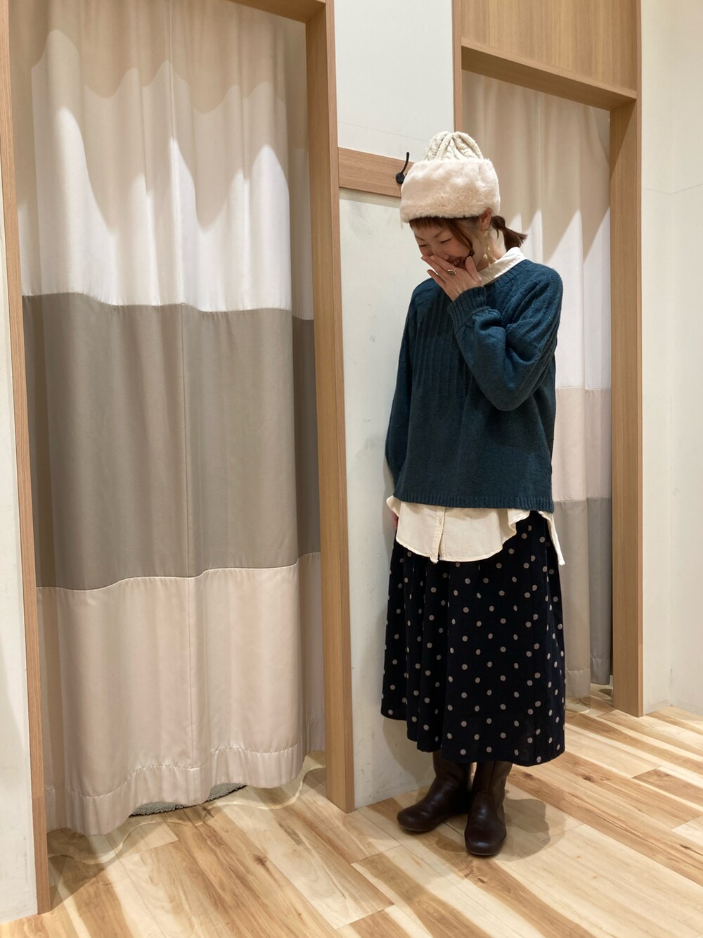 グリーン系のニット/セーター、ホワイト系のシャツ/ブラウス、ブラウン系のブーツを着用したレディースの冬コーディネートの3枚目の写真