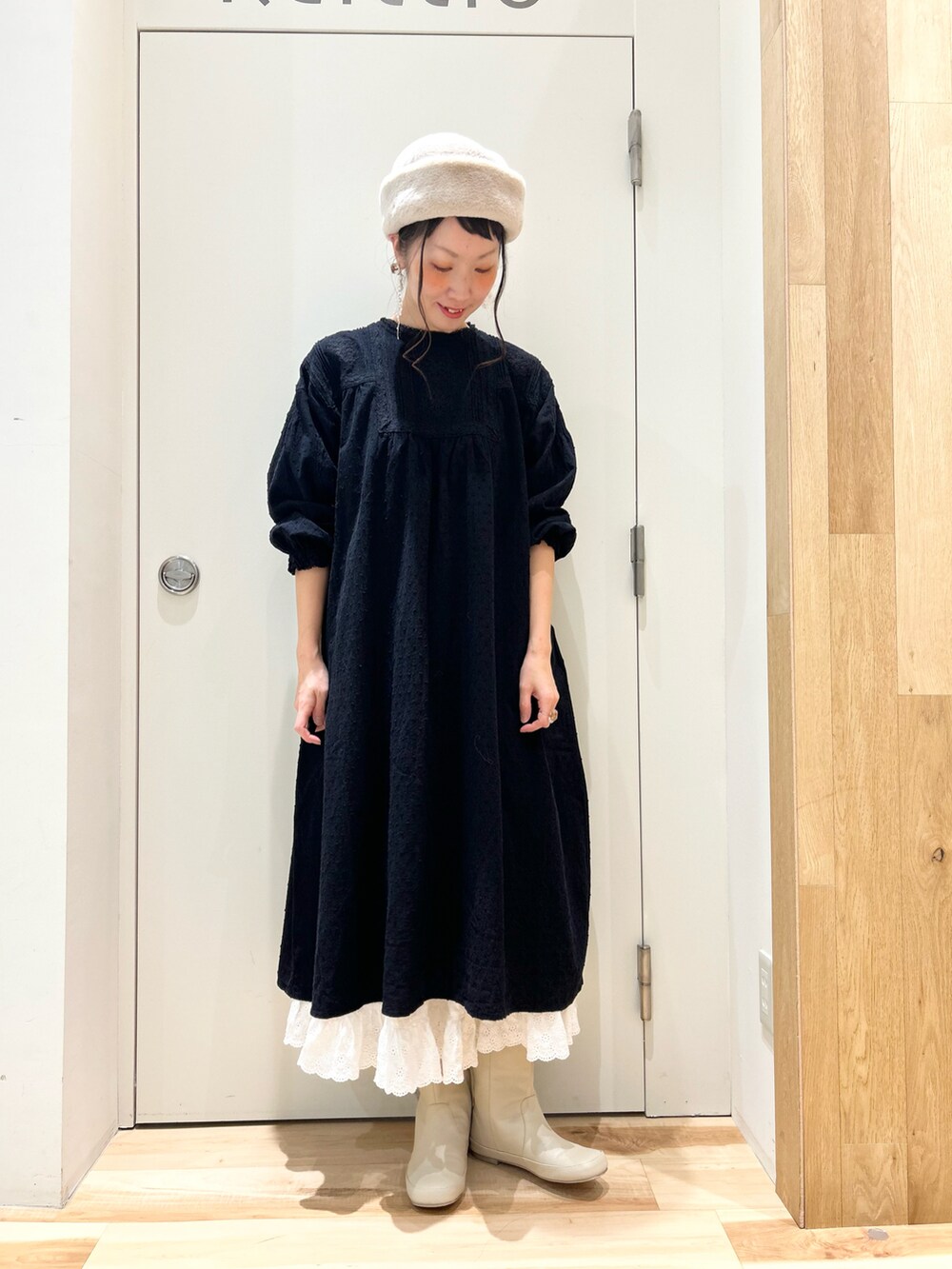 ブラック系のワンピース/ドレス、ホワイト系のスカート、ホワイト系のブーツを着用したレディースの秋コーディネートの2枚目の写真