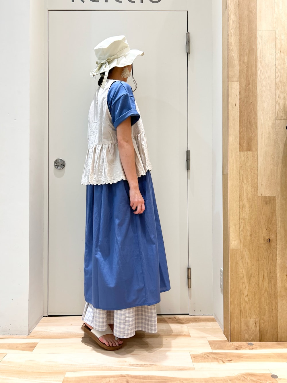 ホワイト系のベスト、ブルー系のワンピース、ブルー系のスカートを着用したレディースの夏コーディネートの2枚目の写真