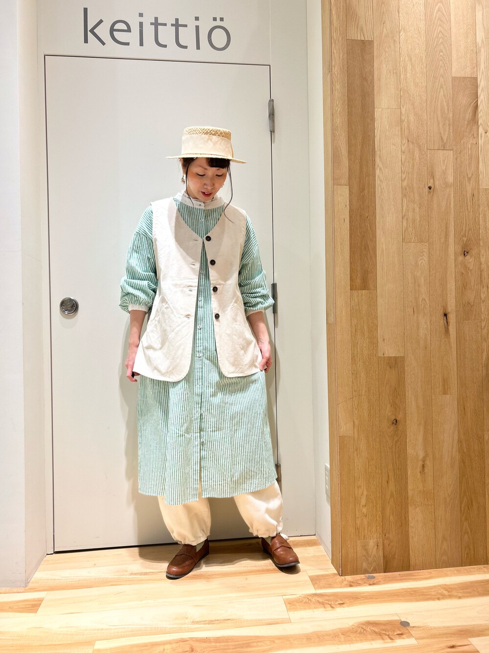 グリーン系のカーディガン/ボレロ、ホワイト系のシャツ/ブラウス、グリーン系のワンピースを着用したレディースの冬コーディネートの3枚目の写真