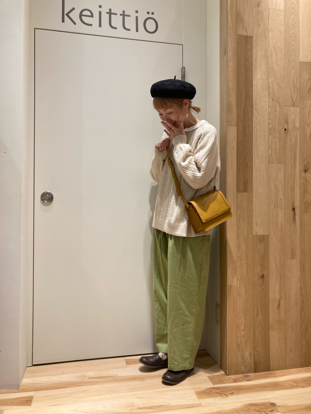 グリーン系のその他パンツ、イエロー系のショルダーバッグ、ホワイト系のニット/セーターを着用したレディースの冬コーディネートの2枚目の写真