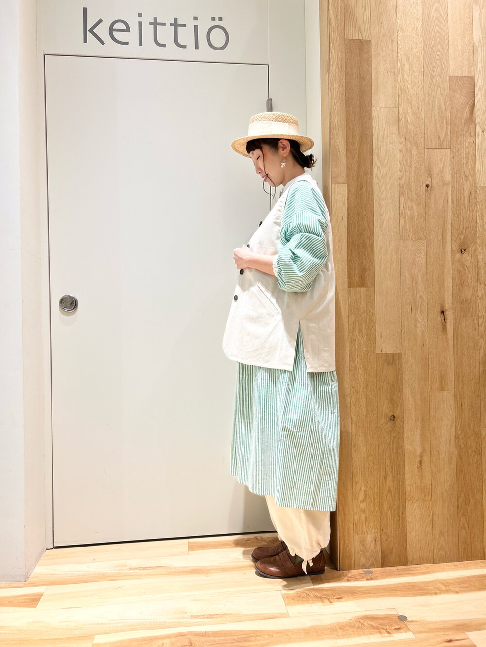 グリーン系のカーディガン/ボレロ、ホワイト系のシャツ/ブラウス、グリーン系のワンピースを着用したレディースの冬コーディネートの5枚目の写真