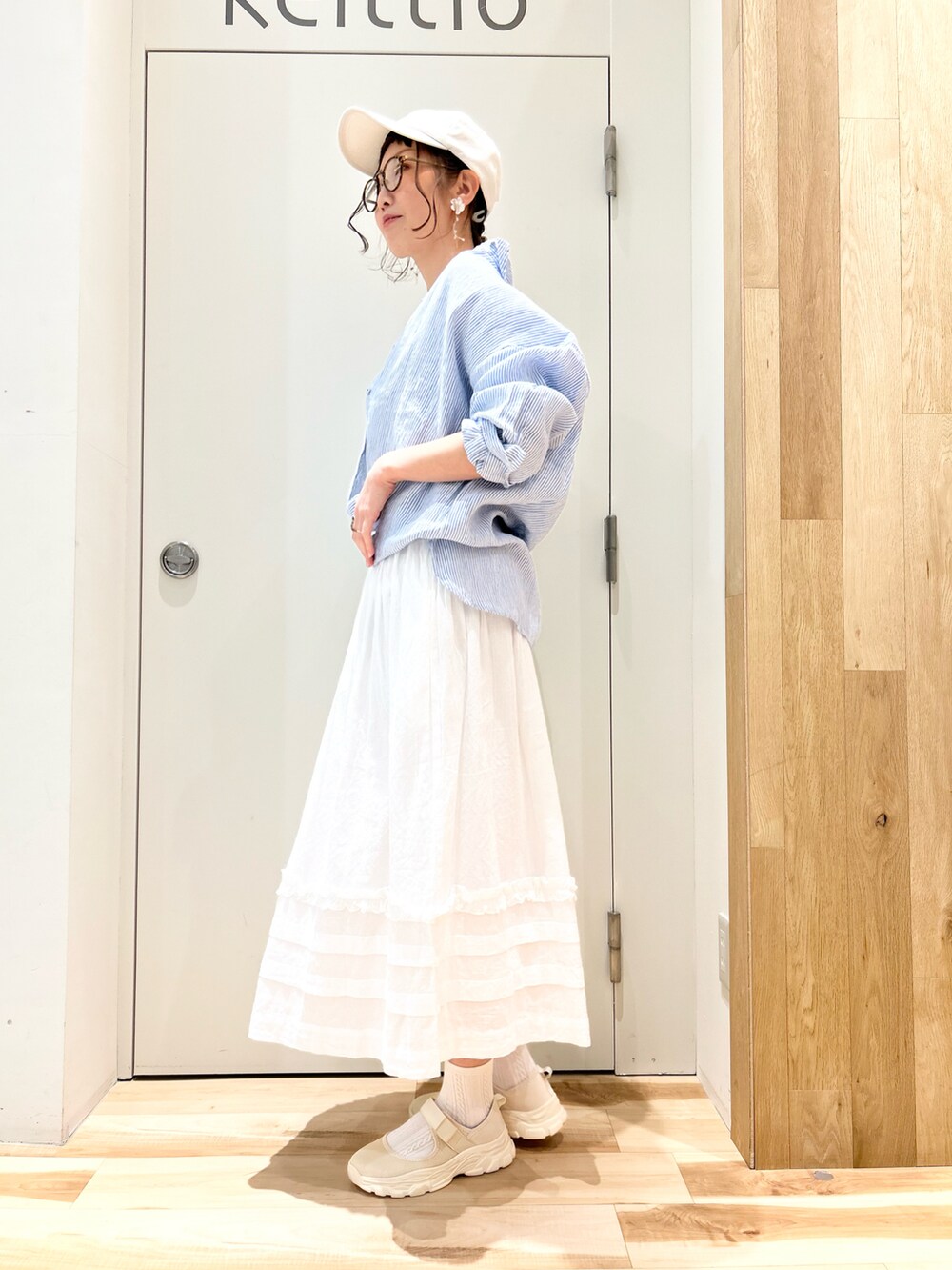 ホワイト系のTシャツ/カットソー、ブルー系のシャツ/ブラウス、ホワイト系のスカートを着用したレディースの春コーディネートの2枚目の写真