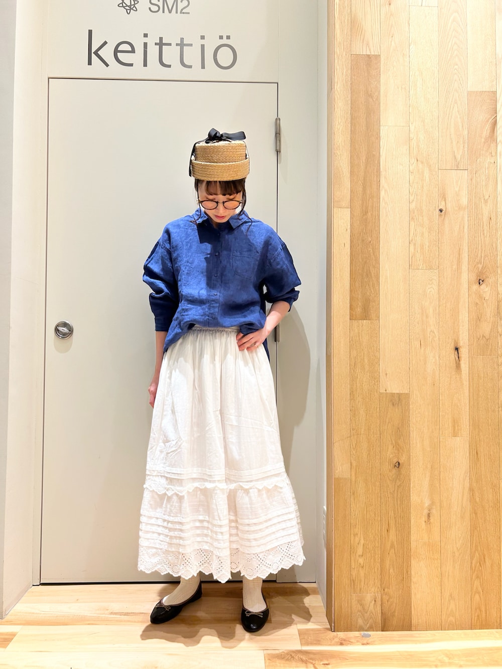 ブルー系のシャツ/ブラウス、ホワイト系のスカート、ブラック系のドレスシューズを着用したレディースの春コーディネートの3枚目の写真