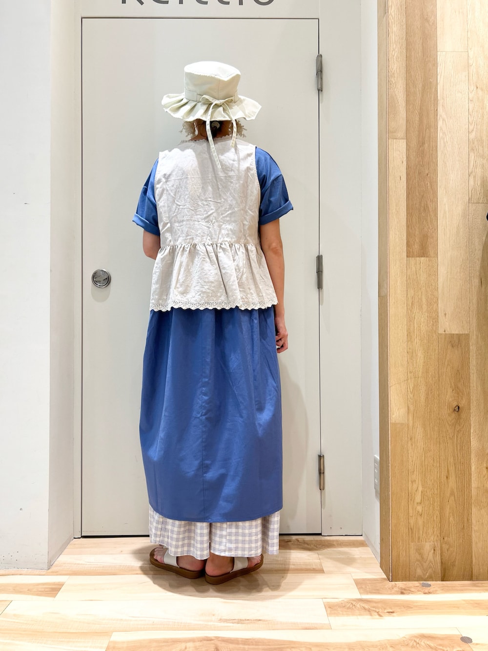 ホワイト系のベスト、ブルー系のワンピース、ブルー系のスカートを着用したレディースの夏コーディネートの3枚目の写真