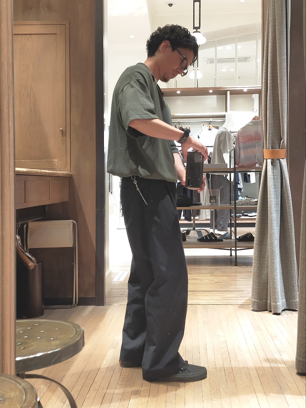 グリーン系のポロシャツ、ブルー系のパンツ、ブラック系のスニーカーを着用したメンズの夏コーディネートの2枚目の写真