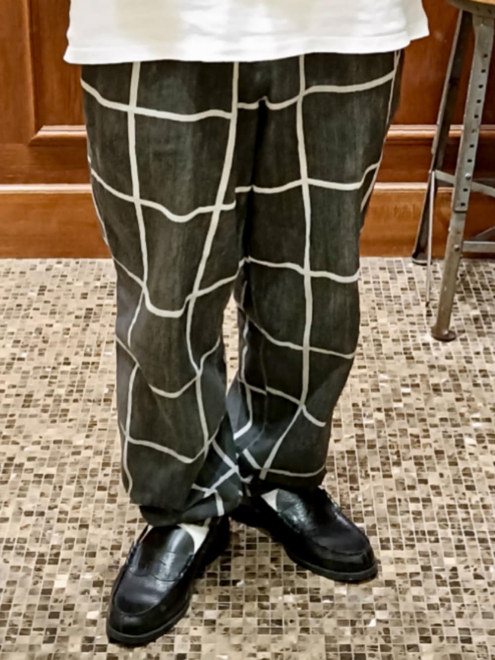 ホワイト系のTシャツ/カットソー、ブラック系のパンツ、ブラック系のローファーを着用したメンズの夏コーディネートの4枚目の写真