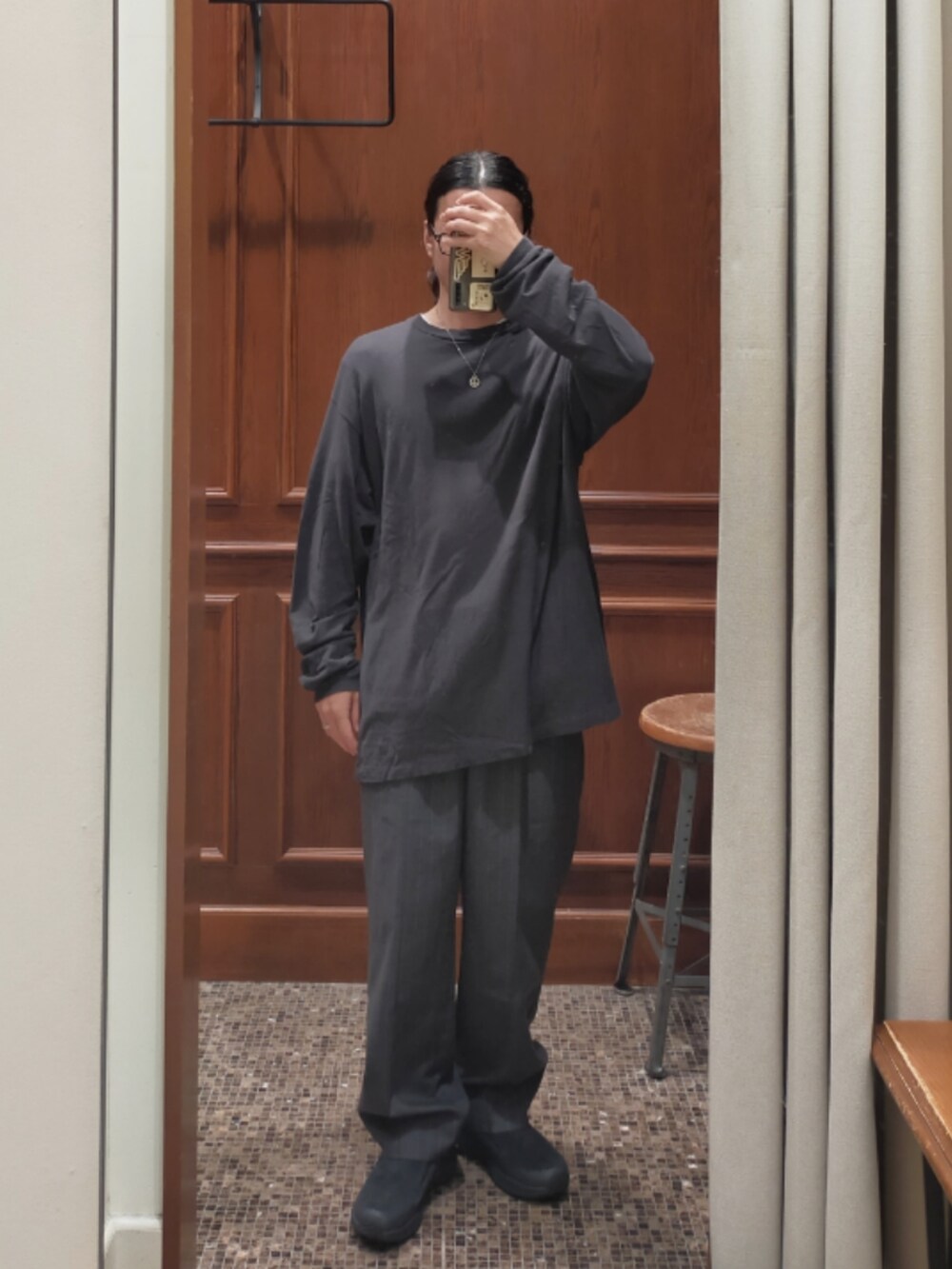 グレー系のTシャツ/カットソー、グレー系のスラックス、ブラック系のスニーカーを着用したメンズの秋コーディネートの2枚目の写真