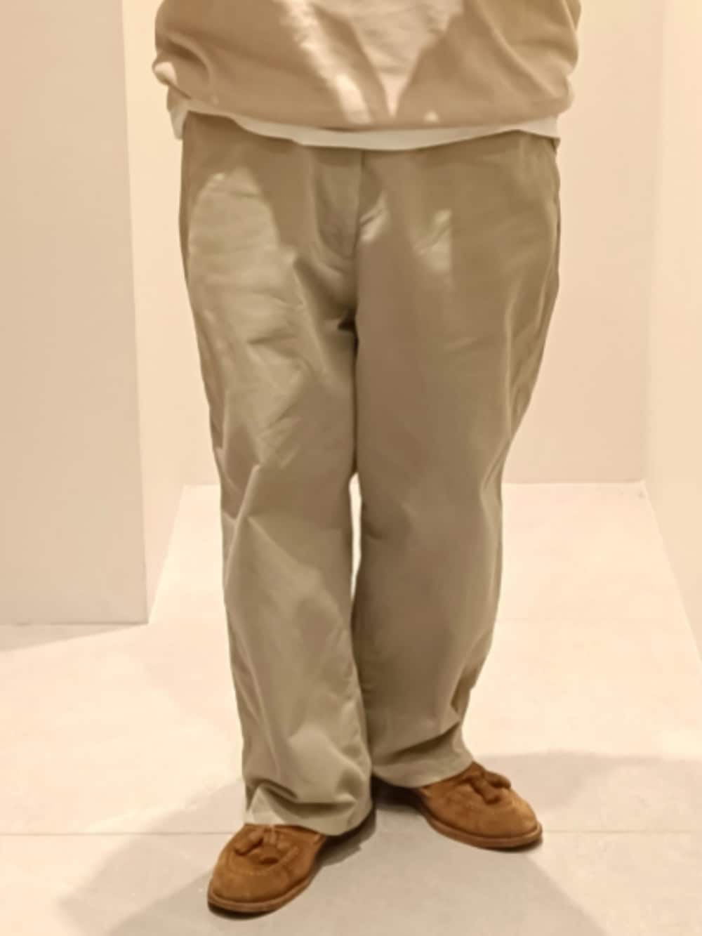 ベージュ系のニット/セーター、ベージュ系のチノパンツ、ブラウン系のローファーを着用したメンズの春コーディネートの3枚目の写真