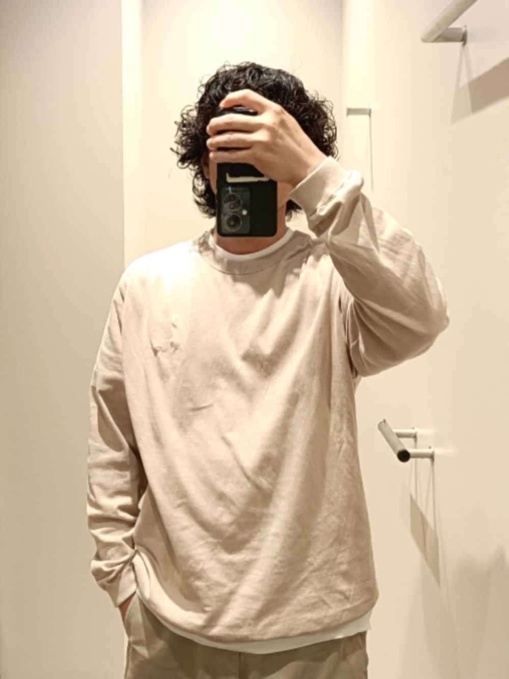 ベージュ系のニット/セーター、ベージュ系のチノパンツ、ブラウン系のローファーを着用したメンズの春コーディネートの2枚目の写真