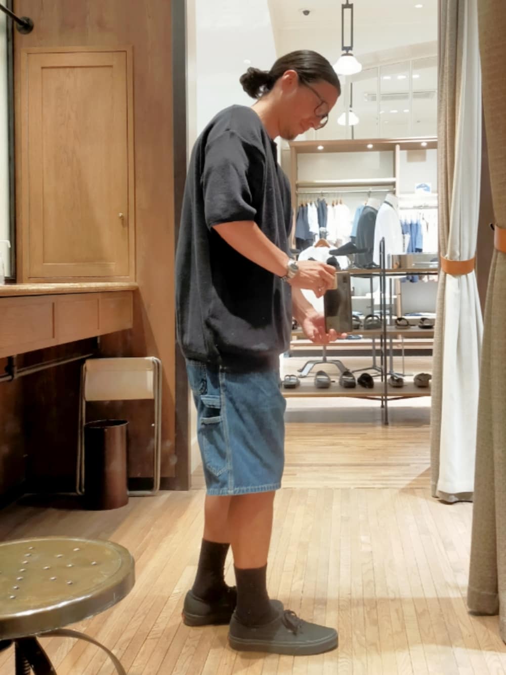 グレー系のニット/セーター、ブルー系のデニムパンツ、ブラック系のスニーカーを着用したメンズの夏コーディネートの2枚目の写真