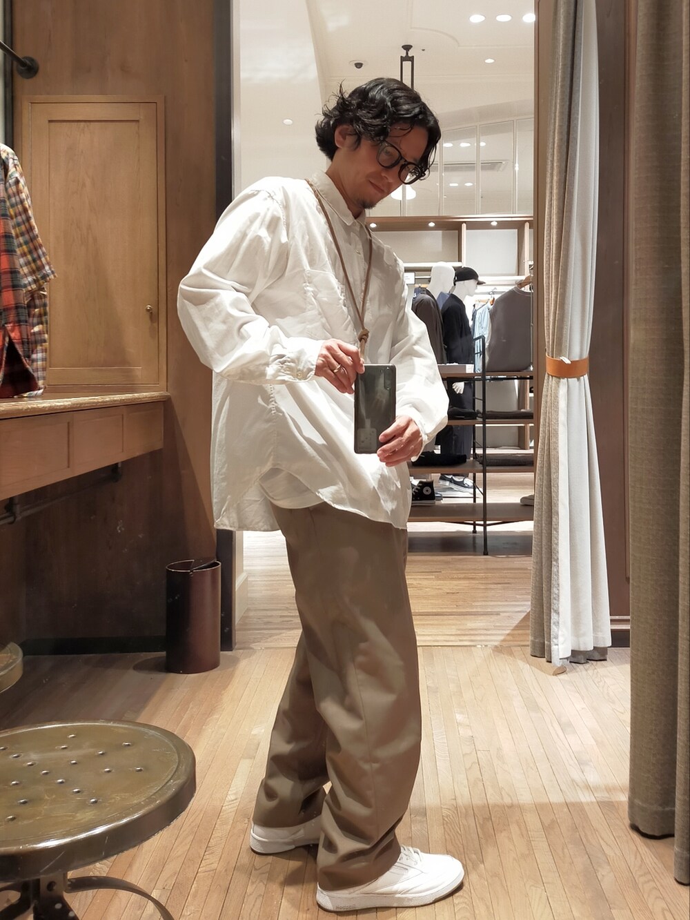 ホワイト系のシャツ/ブラウス、ベージュ系のスラックス、ホワイト系のスニーカーを着用したメンズの秋コーディネートの2枚目の写真