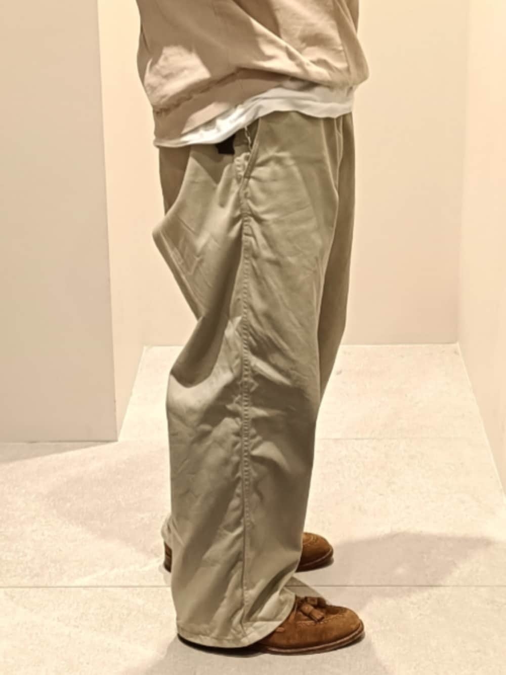 ベージュ系のニット/セーター、ベージュ系のチノパンツ、ブラウン系のローファーを着用したメンズの春コーディネートの4枚目の写真