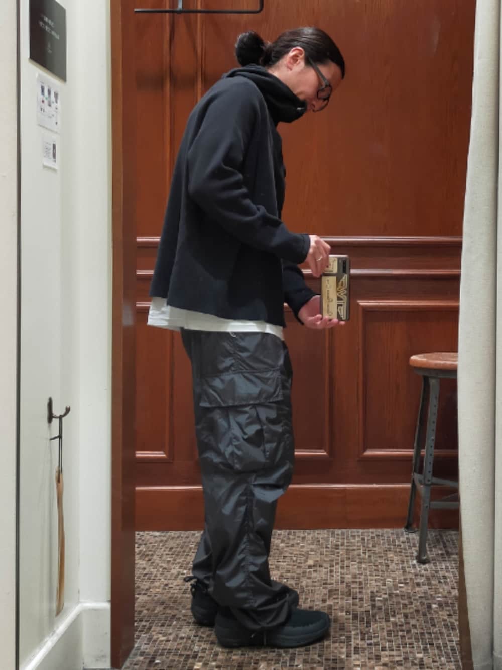 ブラック系のトップス、グレー系のカーゴパンツ、ブラック系のスニーカーを着用したメンズの秋コーディネートの3枚目の写真