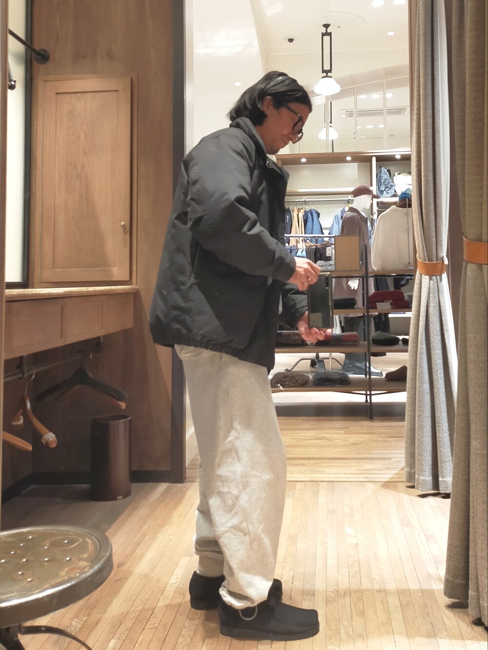 グレー系のニット/セーター、ブラック系のジャケット/アウター、グレー系のスウェットパンツを着用したメンズの冬コーディネートの2枚目の写真