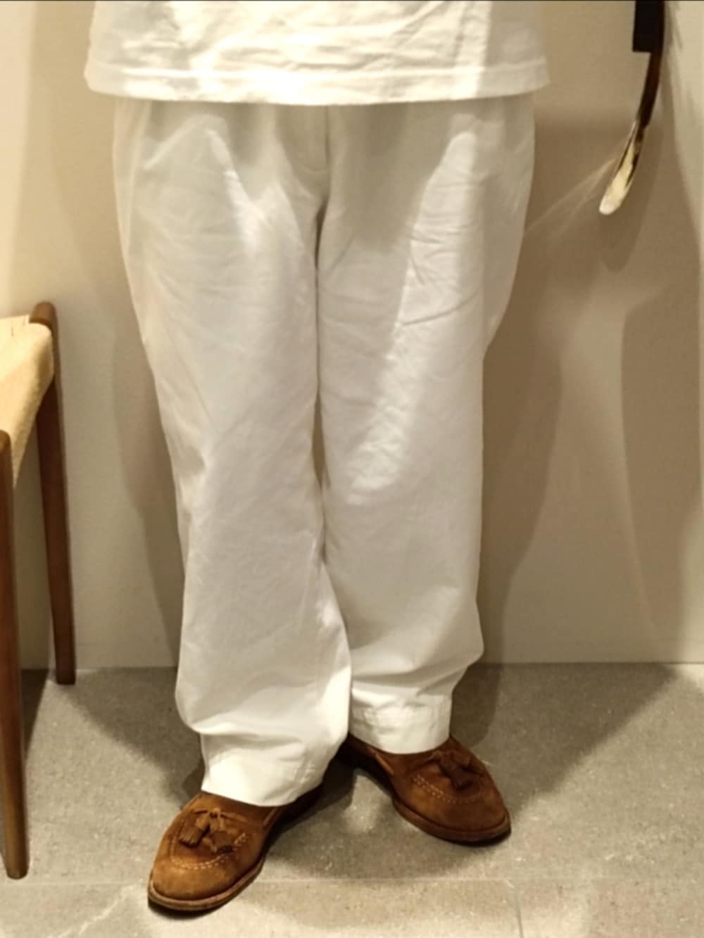 ホワイト系のTシャツ/カットソー、ホワイト系のチノパンツ、ブラウン系のローファーを着用したメンズの夏コーディネートの4枚目の写真