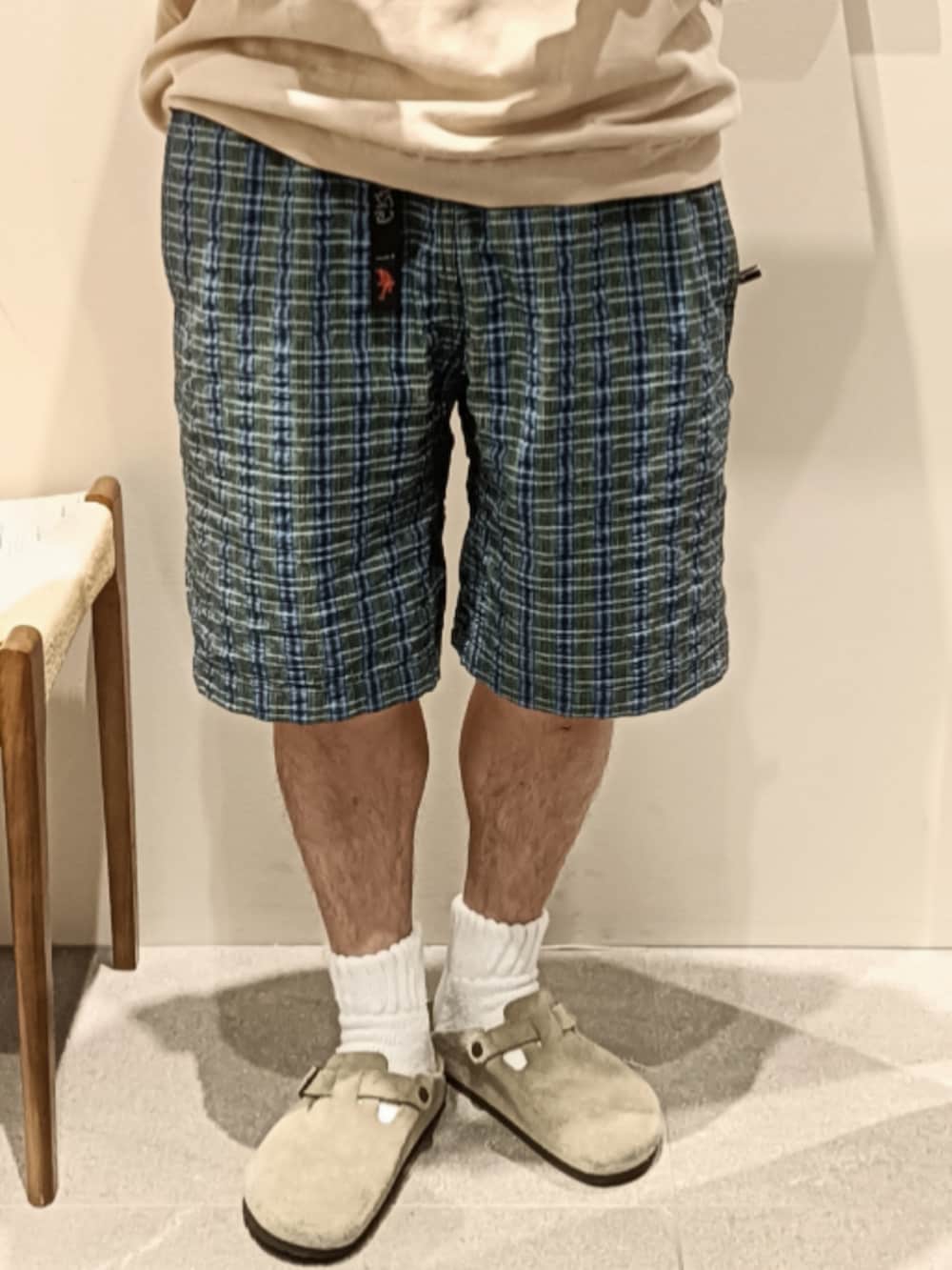 ベージュ系のニット/セーター、ブルー系のパンツ、ベージュ系のサンダルを着用したメンズの春コーディネートの3枚目の写真