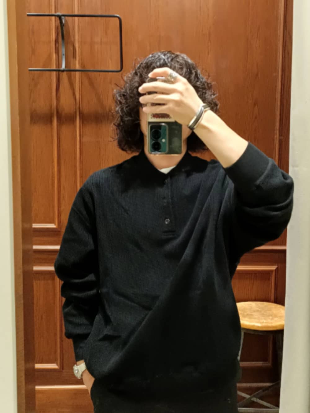 ブラック系のトップス、ブラック系のスラックス、グレー系のスニーカーを着用したメンズの秋コーディネートの3枚目の写真