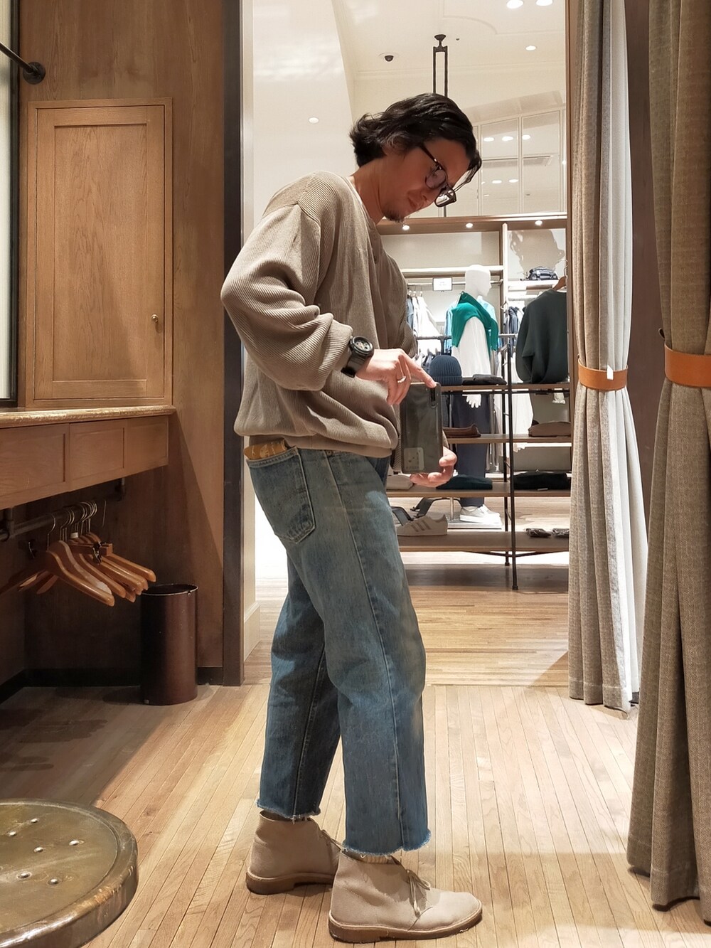 ベージュ系のニット/セーター、ブルー系のデニムパンツ、ベージュ系のブーツを着用したメンズの秋コーディネートの2枚目の写真