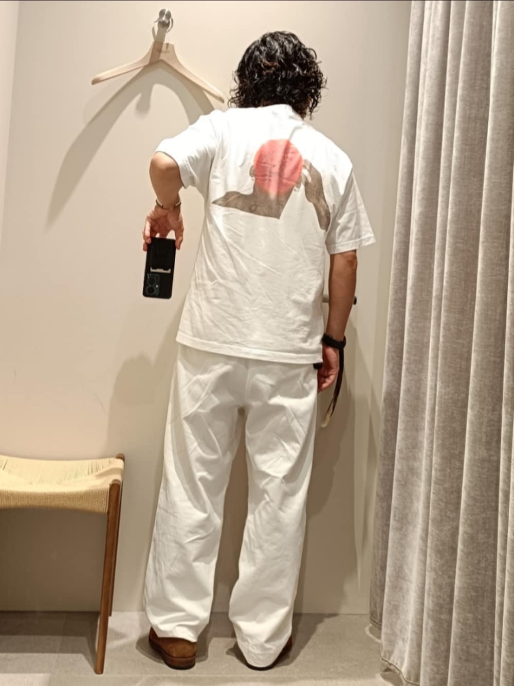 ホワイト系のTシャツ/カットソー、ホワイト系のチノパンツ、ブラウン系のローファーを着用したメンズの夏コーディネートの3枚目の写真