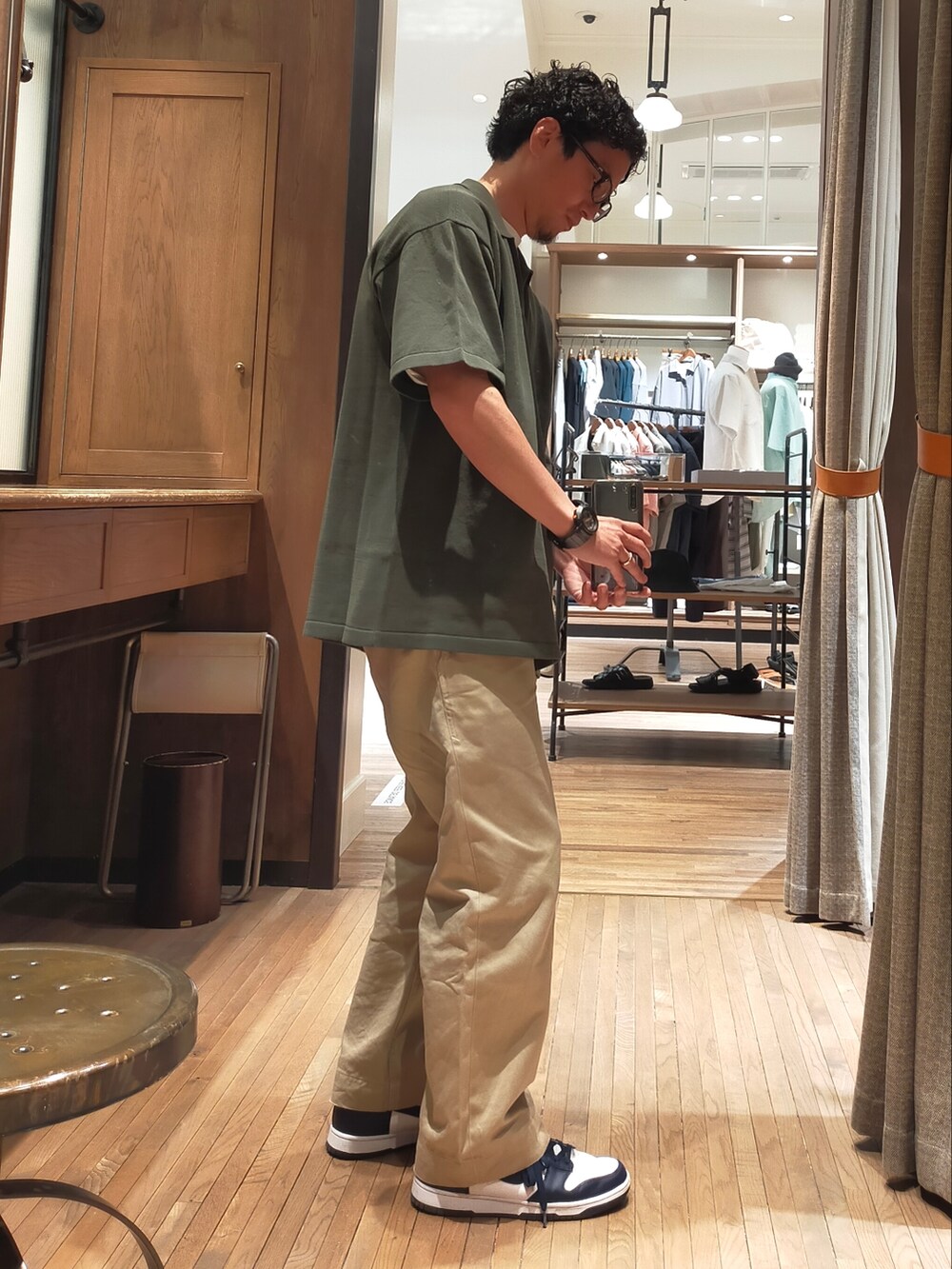 グリーン系のポロシャツ、ベージュ系のチノパンツ、ブルー系のスニーカーを着用したメンズの春コーディネートの2枚目の写真