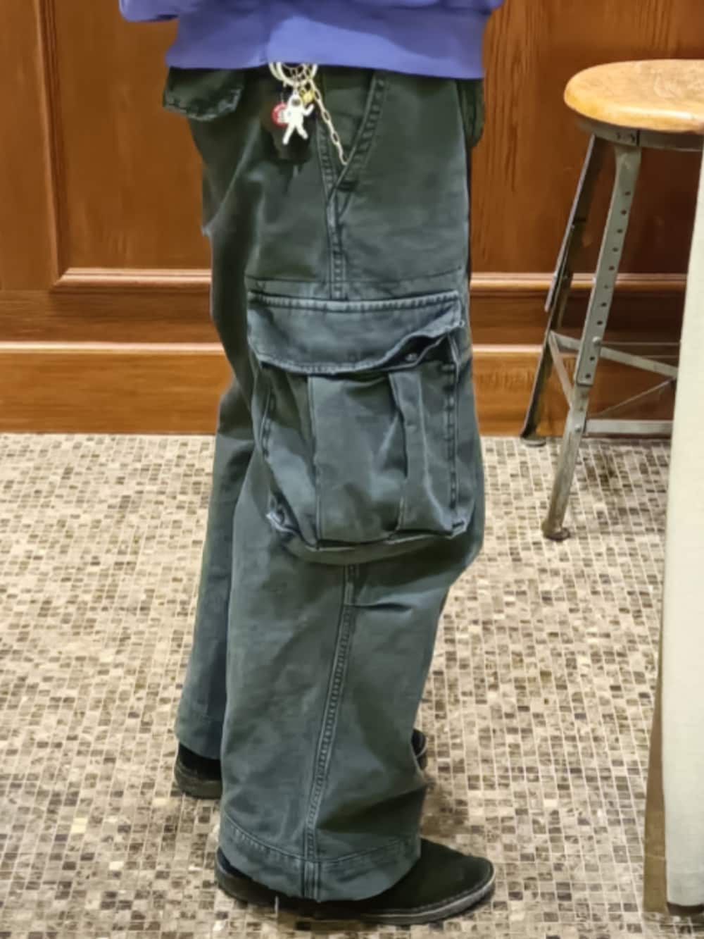 パープル系のパーカー、ブラック系のカーゴパンツ、ブラック系のブーツを着用したメンズの春コーディネートの4枚目の写真