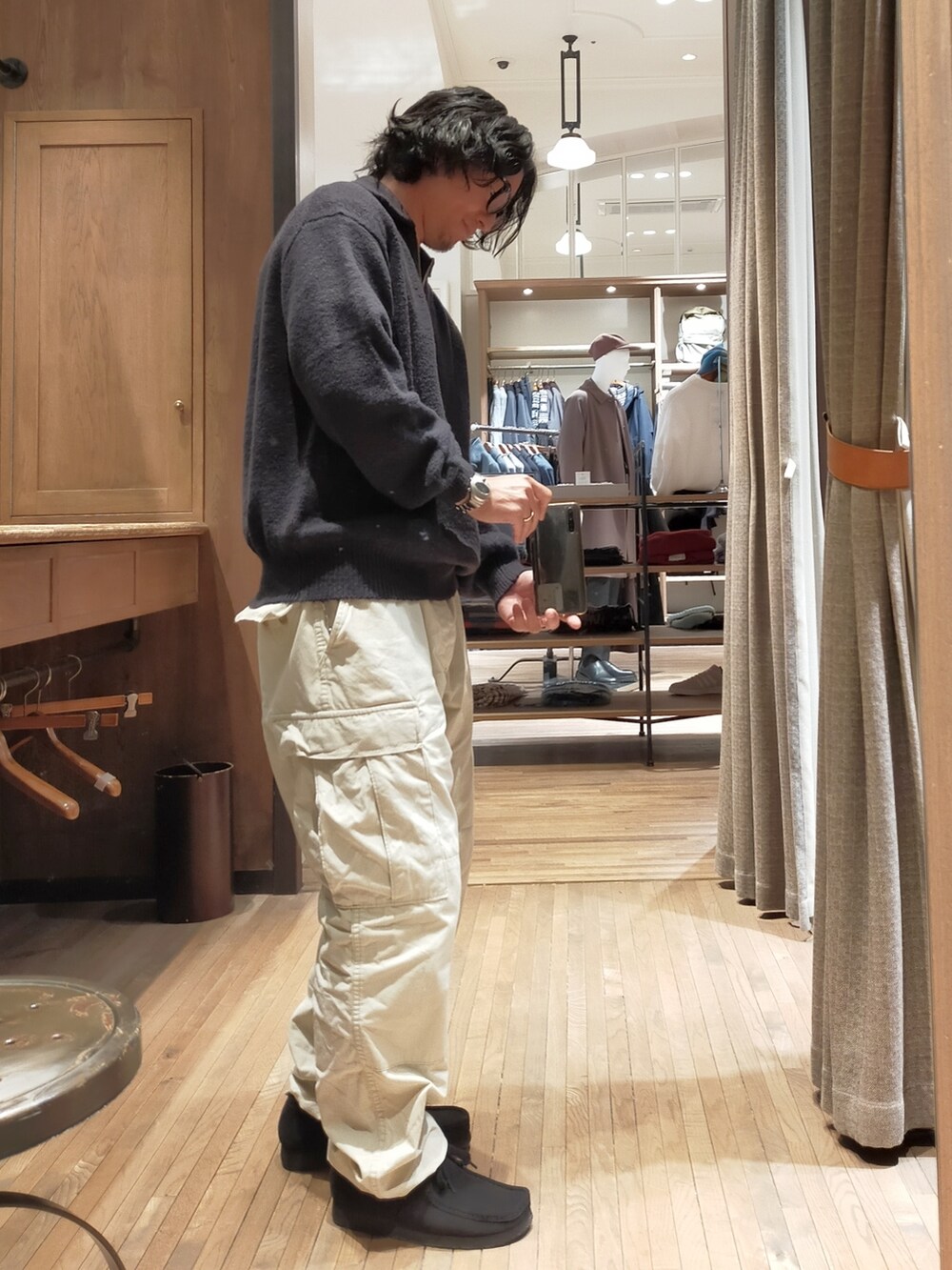 ブラック系のニット/セーター、ホワイト系のカーゴパンツ、ブラック系のブーツを着用したメンズの冬コーディネートの2枚目の写真