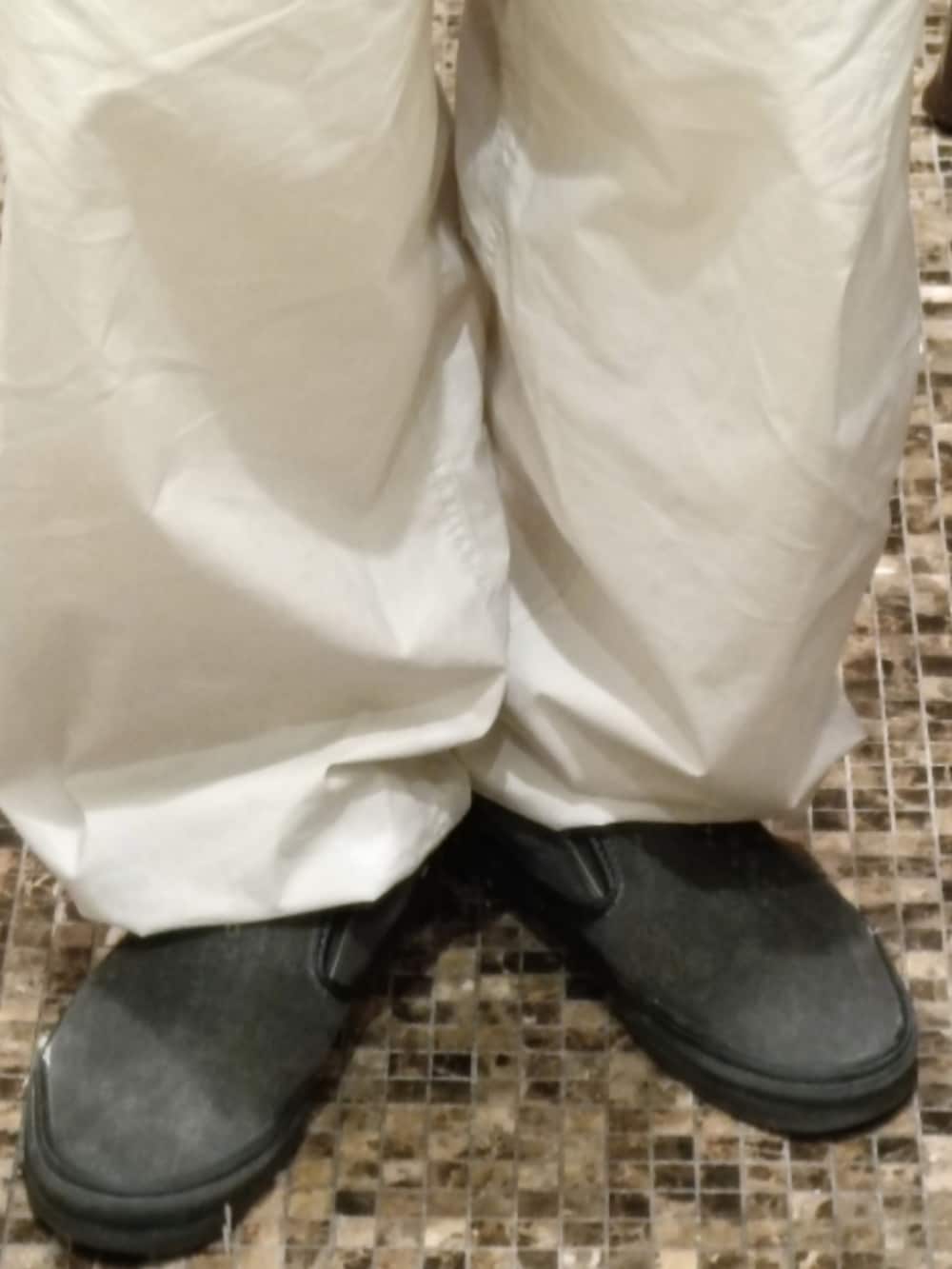 グレー系のスウェット、ホワイト系のパンツ、グレー系のスリッポンを着用したメンズの春コーディネートの5枚目の写真