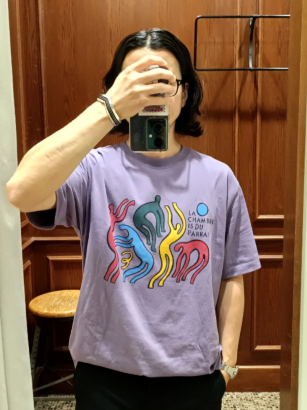 パープル系のTシャツ/カットソー、ブルー系のスラックス、ブラック系のサンダルを着用したメンズの夏コーディネートの3枚目の写真