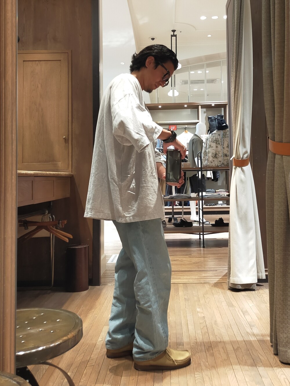 シルバー系のTシャツ/カットソー、ブルー系のデニムパンツ、ベージュ系のブーツを着用したメンズの夏コーディネートの2枚目の写真