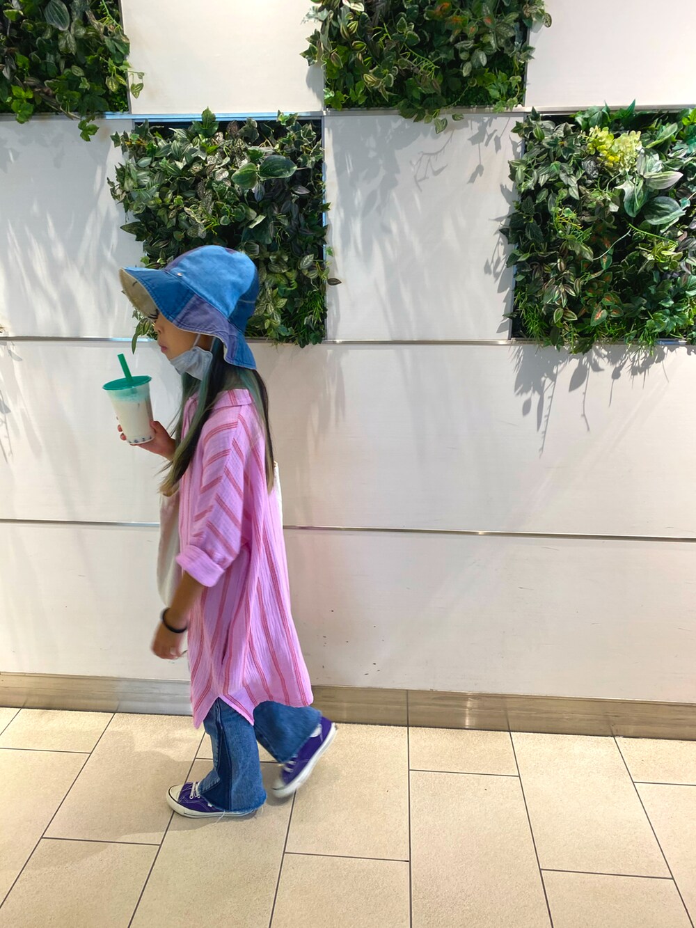 ピンク系のシャツワンピース、ブルー系のデニムパンツ、パープル系のスニーカーを着用したキッズの秋コーディネートの2枚目の写真