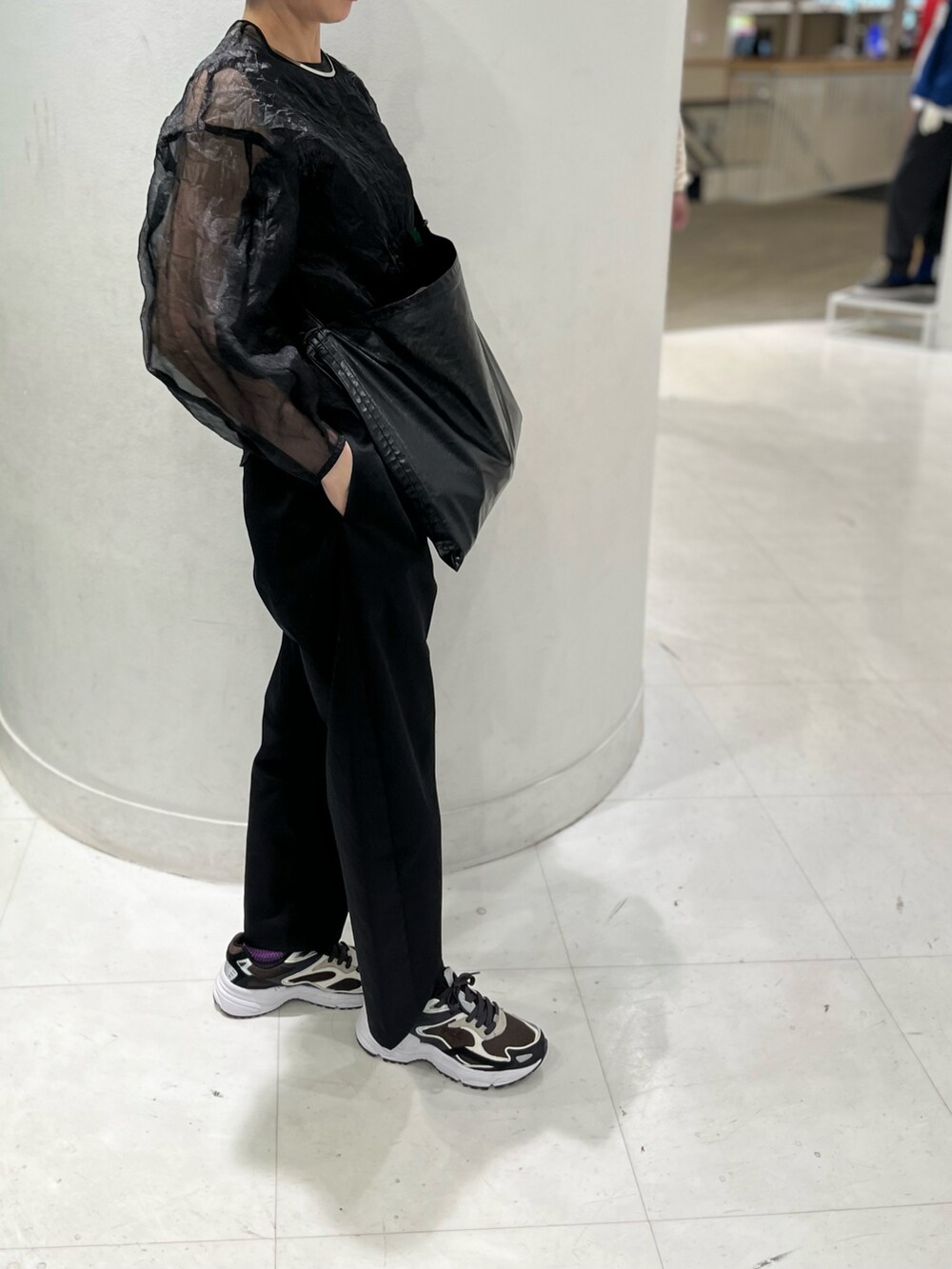 ブラック系のショルダーバッグ、ブラック系のシャツ/ブラウス、ブルー系のスニーカーを着用したレディースの春コーディネートの3枚目の写真