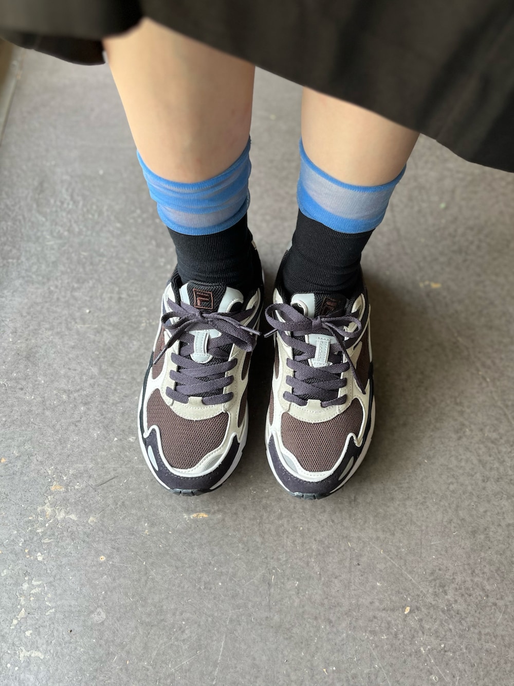 ブラック系のスニーカー、ブルー系のスニーカー、ホワイト系のスニーカーを着用したレディースの春コーディネートの2枚目の写真