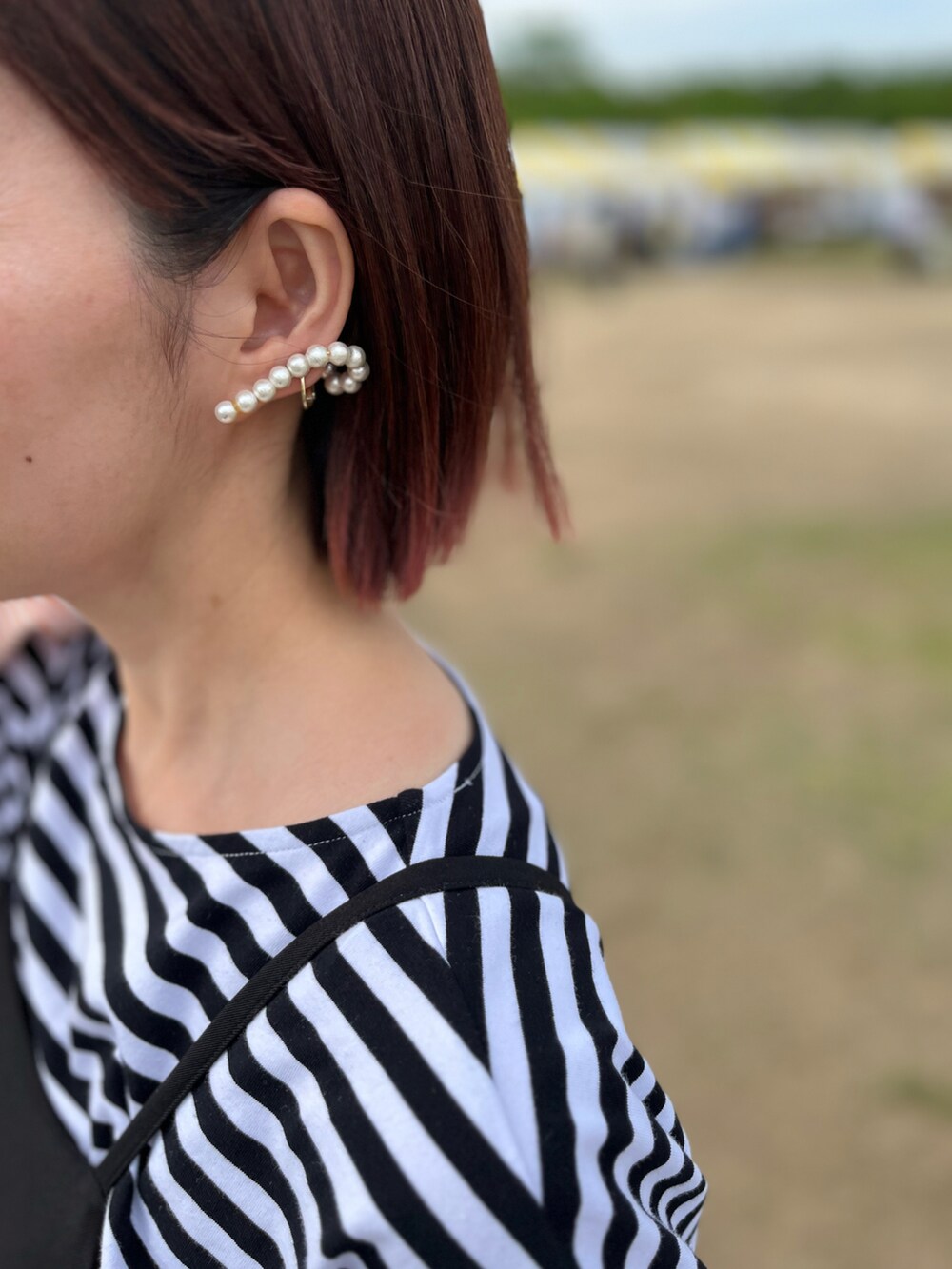 ブラック系のTシャツ/カットソー、シルバー系のスニーカー、シルバー系のバッグを着用したレディースの春コーディネートの3枚目の写真