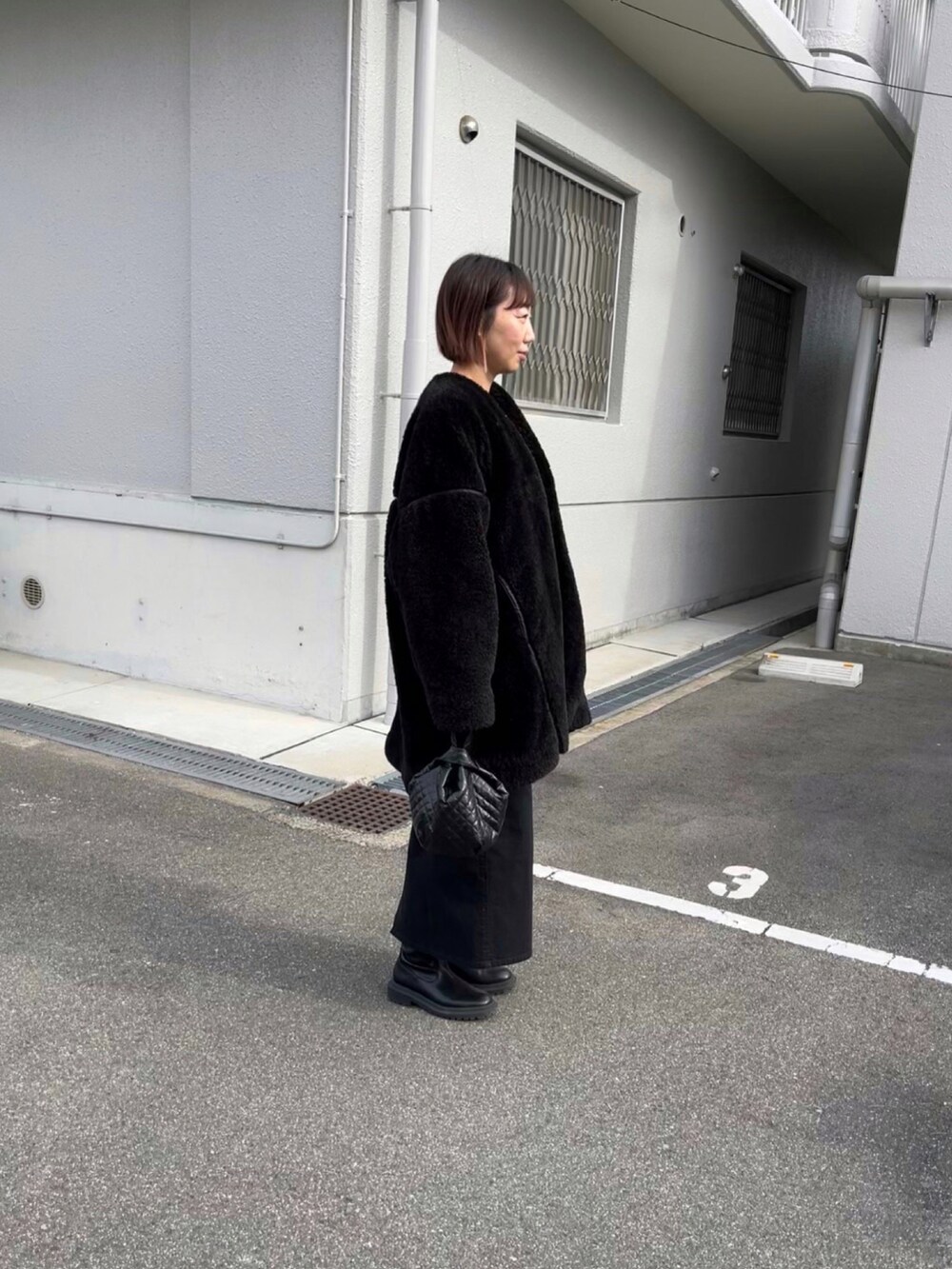 ブラック系のその他アウター、ブラック系のTシャツ/カットソー、ブラック系のジャンパースカートを着用したレディースの冬コーディネートの2枚目の写真