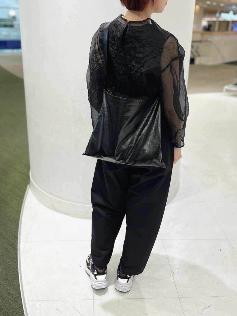 ブラック系のショルダーバッグ、ブラック系のシャツ/ブラウス、ブルー系のスニーカーを着用したレディースの春コーディネートの4枚目の写真