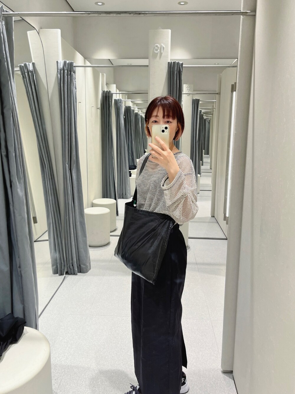 ホワイト系のTシャツ/カットソー、ブラック系のショルダーバッグ、ブラック系のスカートを着用したレディースの春コーディネートの3枚目の写真