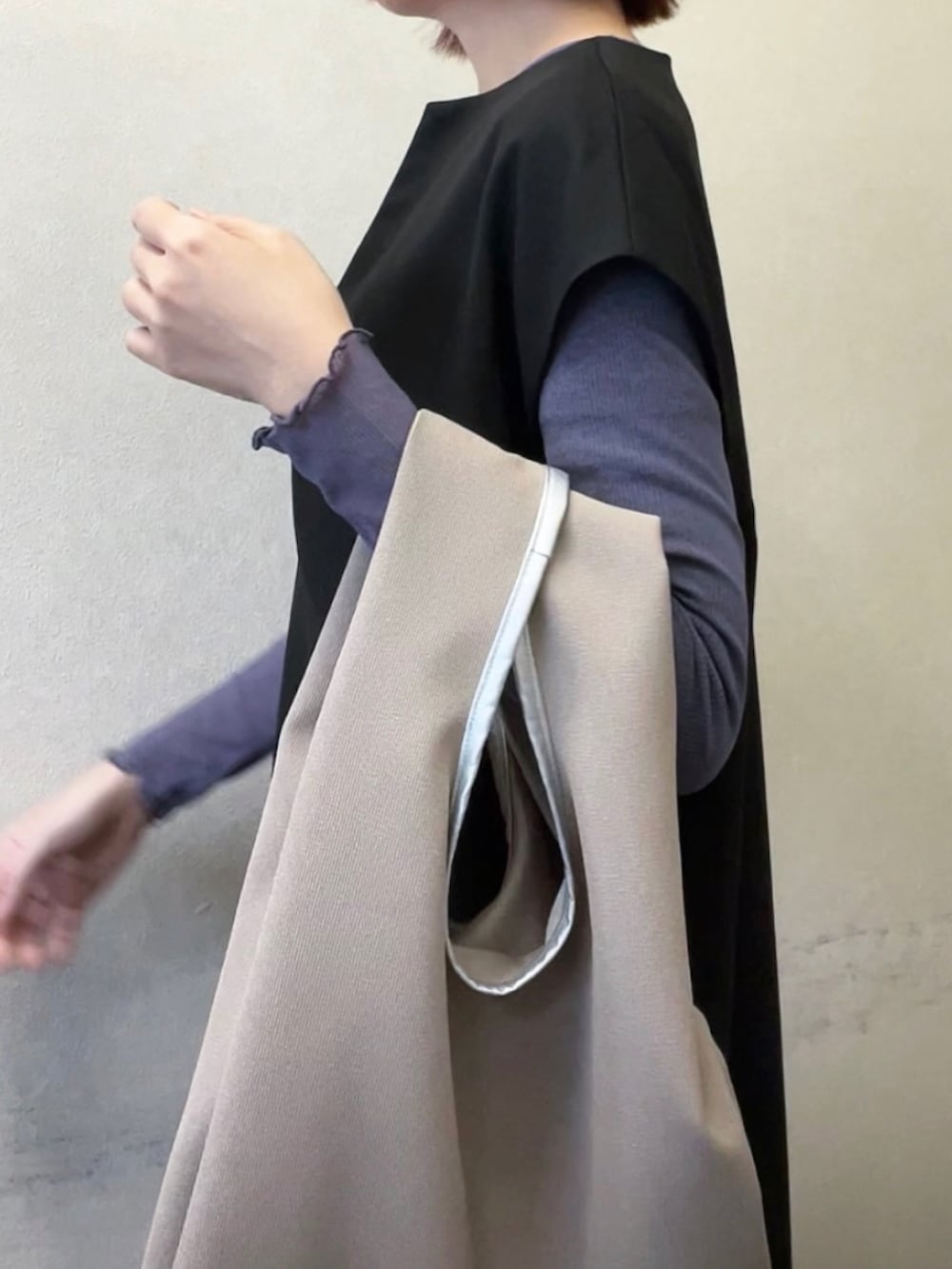 ブラック系のワンピース、ベージュ系のバッグを着用したレディースの冬コーディネートの2枚目の写真