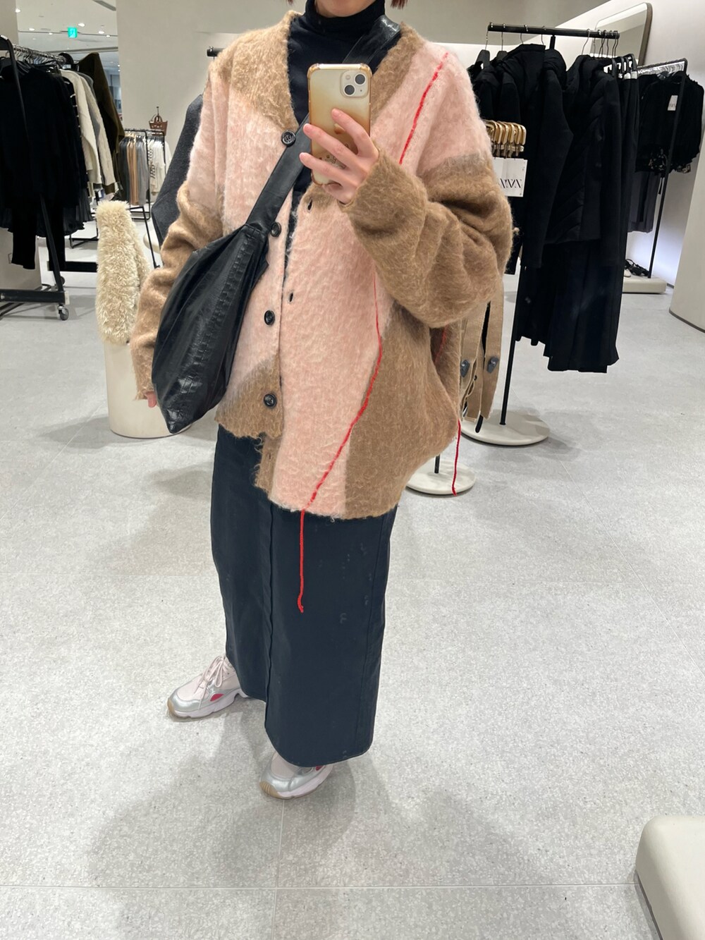 ベージュ系のカーディガン/ボレロ、ブラック系のショルダーバッグ、ブラック系のジャンパースカートを着用したレディースの冬コーディネートの2枚目の写真