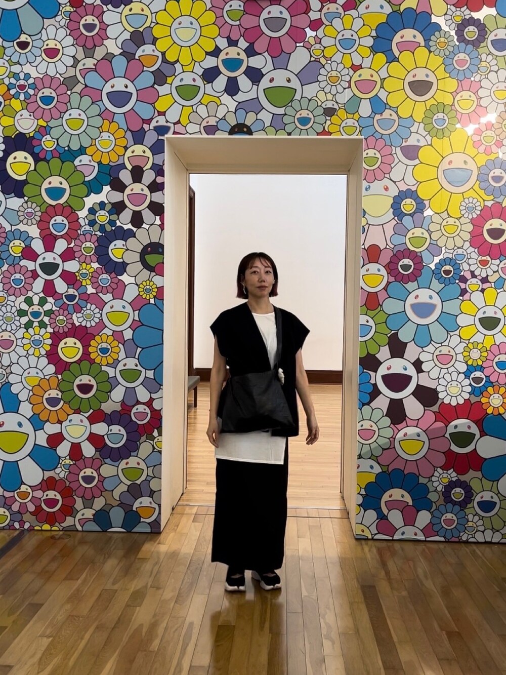 ブラック系のスカート、ホワイト系のタンクトップ、ブラック系のショルダーバッグを着用したレディースの夏コーディネートの3枚目の写真