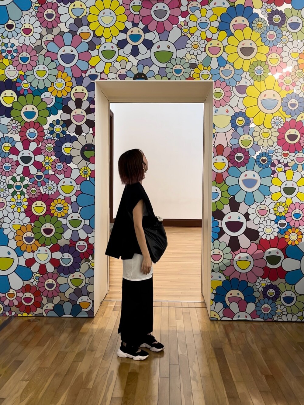 ブラック系のスカート、ホワイト系のタンクトップ、ブラック系のショルダーバッグを着用したレディースの夏コーディネートの2枚目の写真