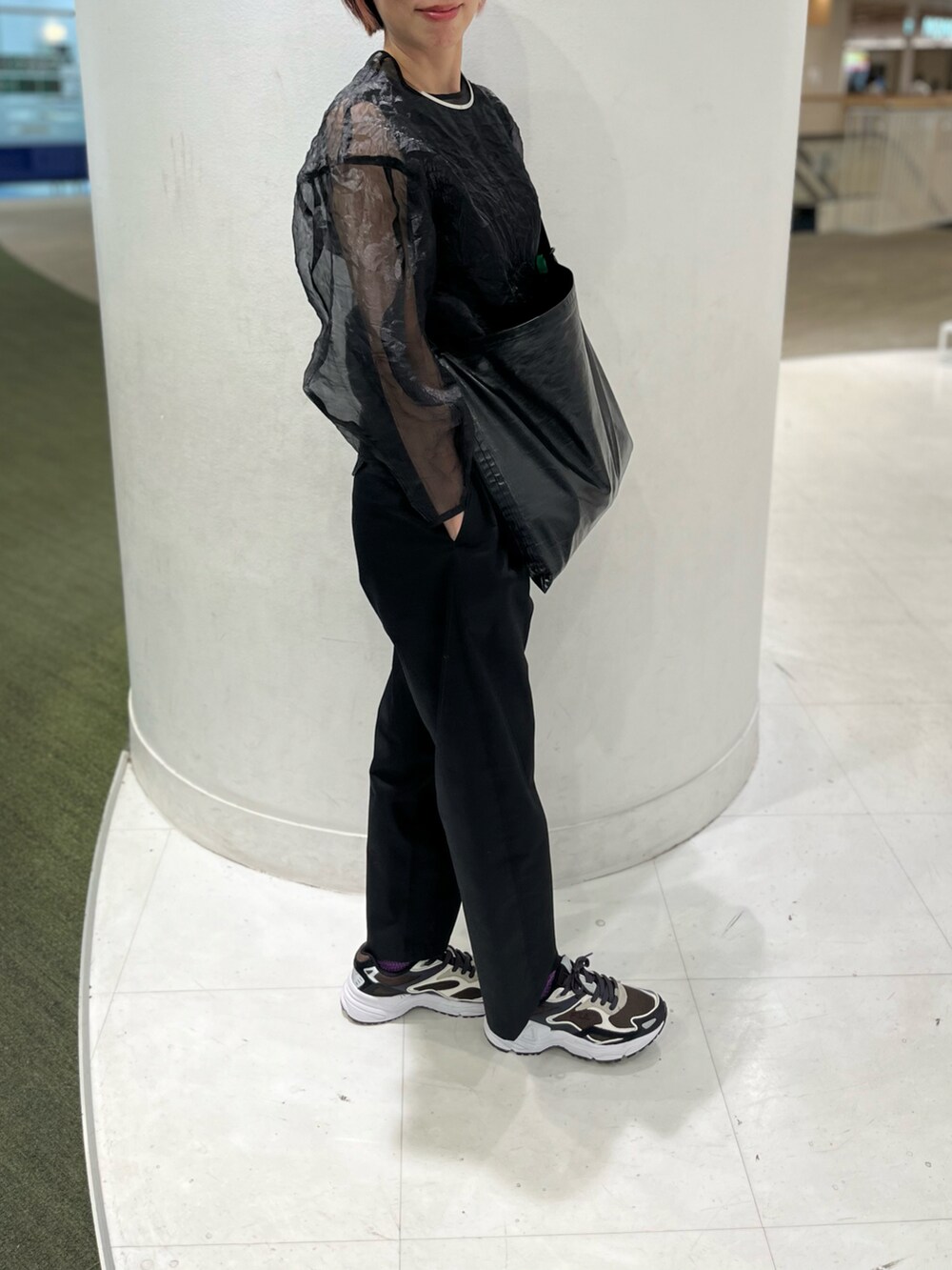 ブラック系のショルダーバッグ、ブラック系のシャツ/ブラウス、ブルー系のスニーカーを着用したレディースの春コーディネートの5枚目の写真