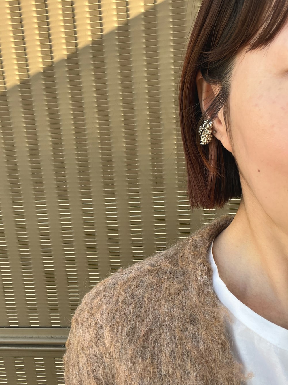 ベージュ系のカーディガン/ボレロ、ブラック系のバッグ、ブラック系のスカートを着用したレディースの冬コーディネートの2枚目の写真