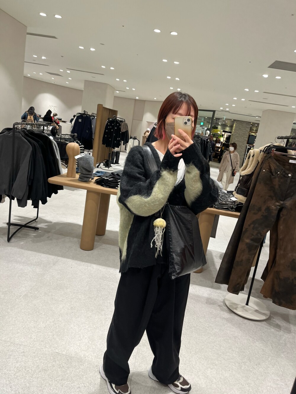 ブラック系のチノパンツ、ブラック系のショルダーバッグ、ブラック系のニット/セーターを着用したレディースの秋コーディネートの3枚目の写真