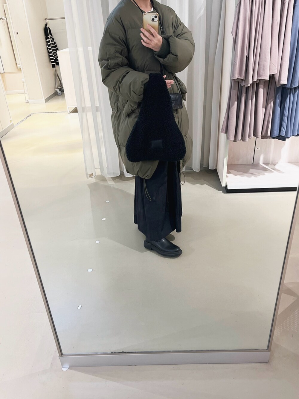 ブラック系のショルダーバッグ、ブラック系のスカート、ブラック系のバッグを着用したレディースの冬コーディネートの2枚目の写真