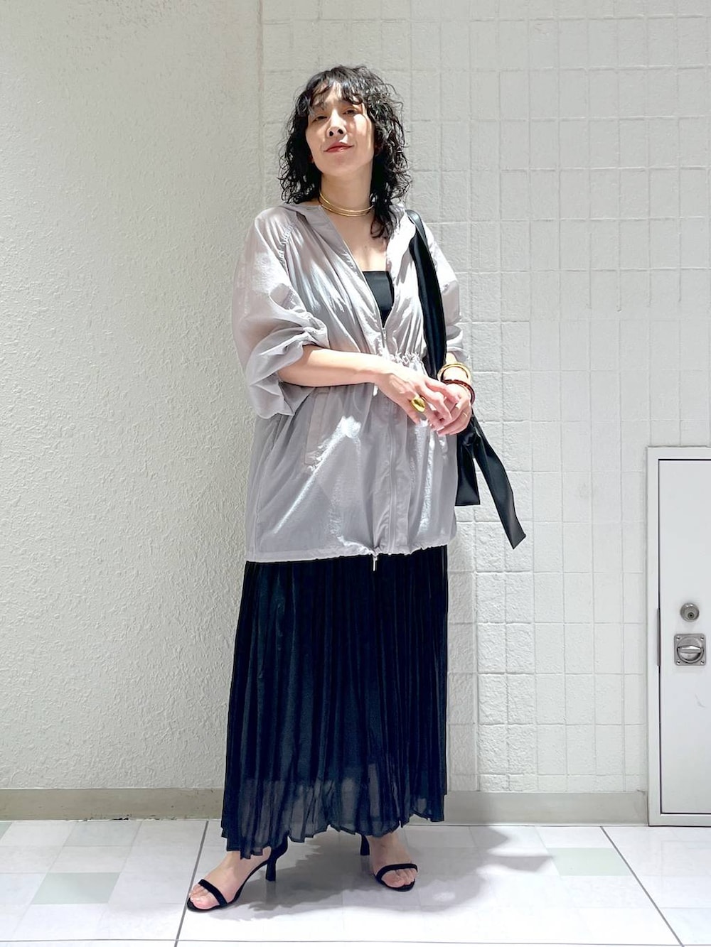 ブラック系のショルダーバッグ、グレー系のブルゾン、ブラック系のサンダルを着用したレディースの春コーディネートの4枚目の写真