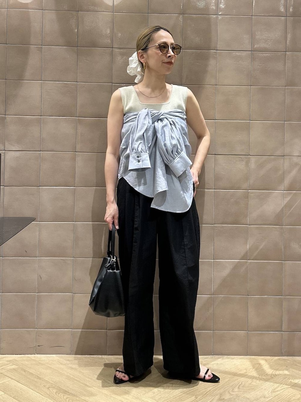 ブラック系のショルダーバッグ、ブルー系のシャツ/ブラウス、ホワイト系のタンクトップを着用したレディースの春コーディネートの5枚目の写真