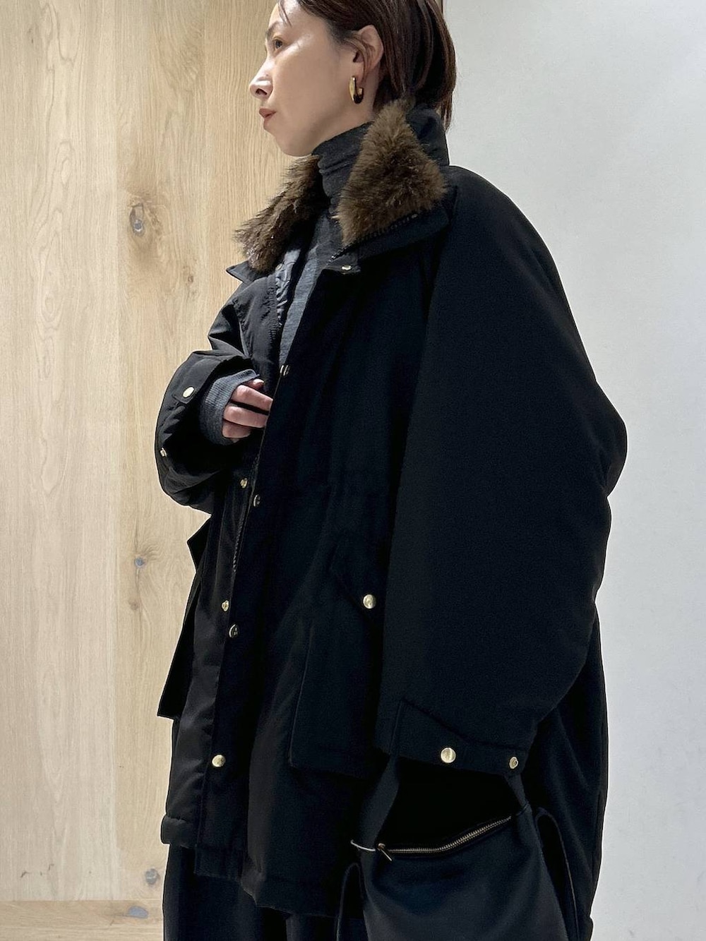 ブラック系のショルダーバッグ、ブラック系のモッズコート、グレー系のニット/セーターを着用したレディースの秋コーディネートの2枚目の写真