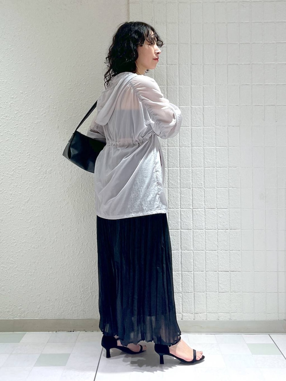 ブラック系のショルダーバッグ、グレー系のブルゾン、ブラック系のサンダルを着用したレディースの春コーディネートの3枚目の写真